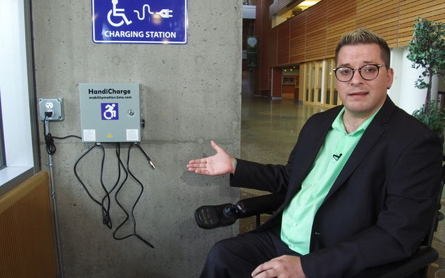 ADA Administrator Blayne Amson shows a wheelchair charging station