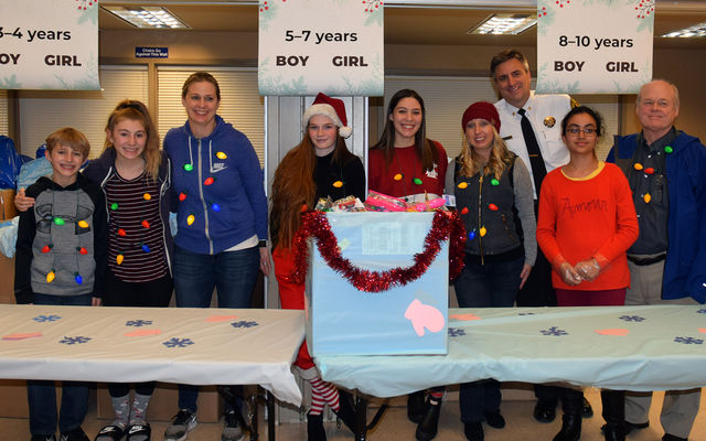 Staff and others gather around a box of toys donated for the drive.