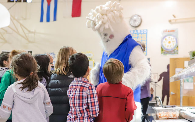 Students gather around the Carbon Yeti, Bellevue's conservation mascot, at the awards ceremony Dec. 12.