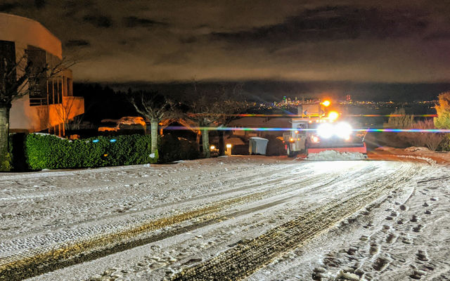 A snowplow clears a neighborhood street in South Bellevue.