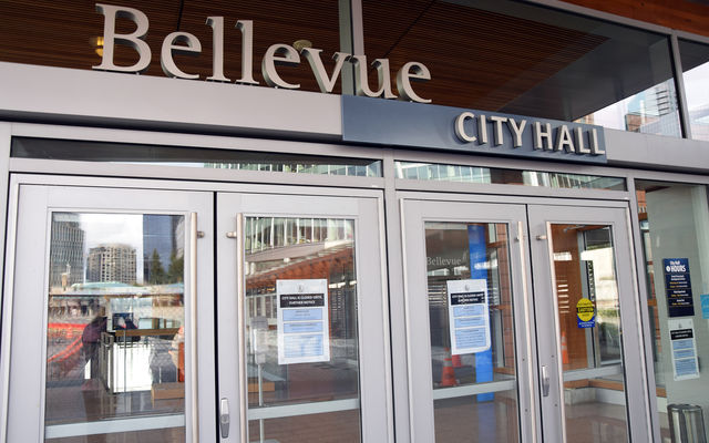 Signs at the entrance to City Hall indicate its closure to public use.