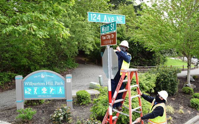 Transportation workers install an honorary street sign celebrating sister city Yao, Japan.
