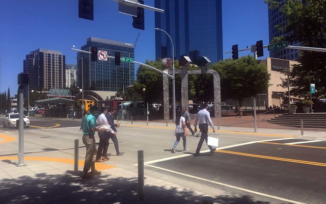 People walk across 106th Avenue Northeast.