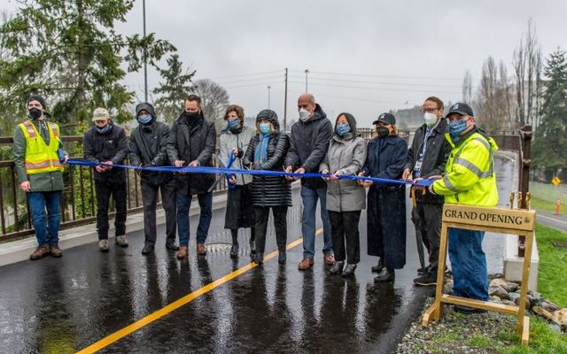 Group of people cutting ribbon on new Mountains to Sound Greenway Trail section