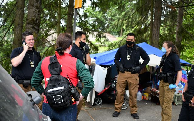 A Community Crisis Assistance Team confers about an individual in crisis at a homeless encampment.
