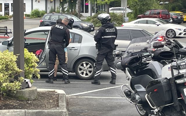 Motorcycle patrol officers arrest a warrant suspect in a Bellevue parking lot.
