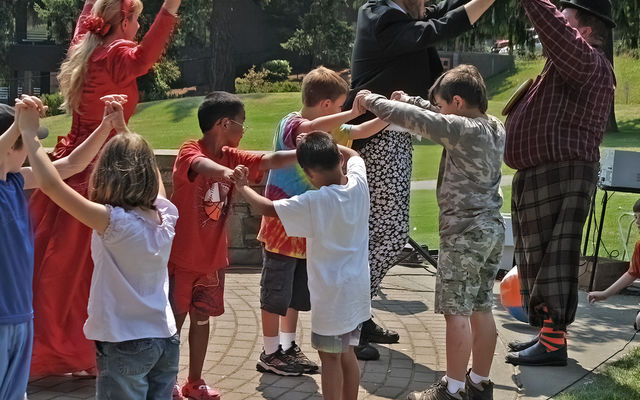 Actors and audience participate in outdoor theater.