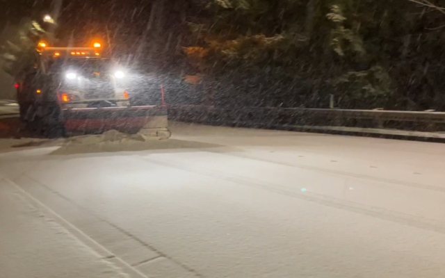 Snow plow in snowy conditions on Bellevue roadway