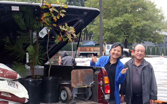 A Bellevue couple give a thumbs-up when they pick up a pair of trees in the 2022 giveaway.