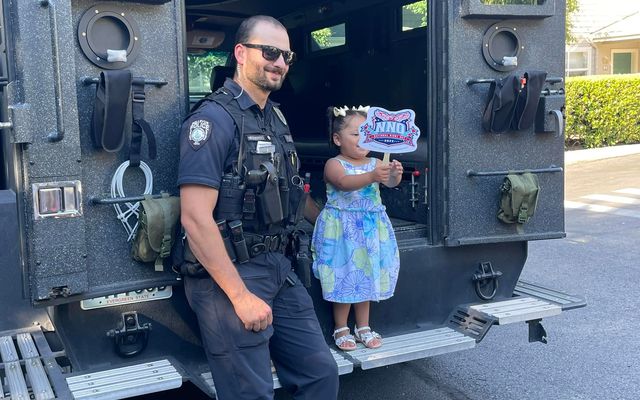 An officer shows off the Bellevue police's SWAT vehicle at a 2023 National Night Out event..