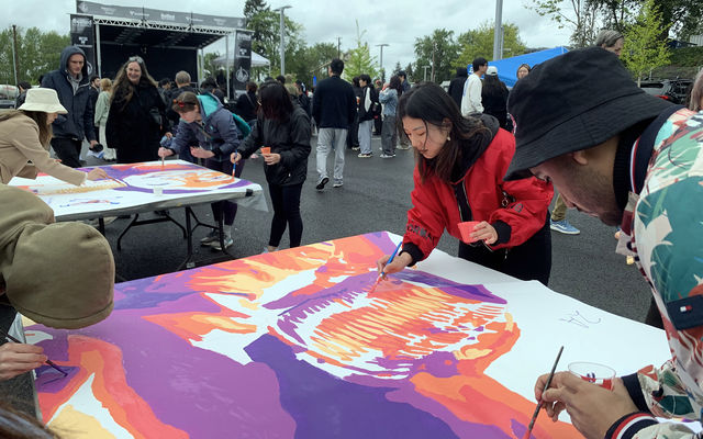 People paint on a large sheet at a BelRed arts event.