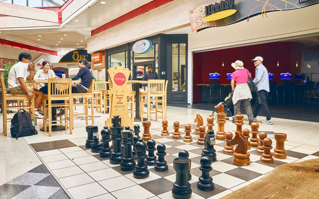 People shop or visit at the Crossroads Bellevue mall by a large chess set. Photo by Stanton Stephens