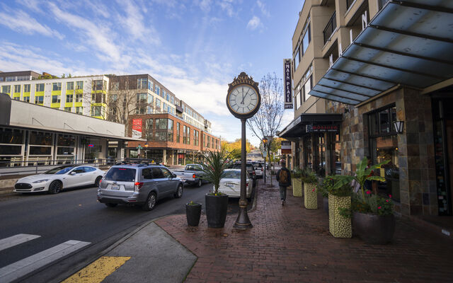 Photo of block on Old Main St. showing clock, businesses and cars on road in downtown Bellevue. 