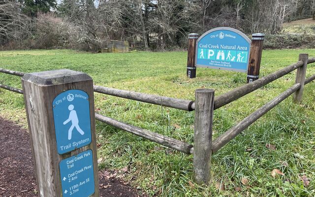 A trail to the Coal Creek Natural Area with a signpost.