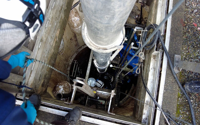 Utilities staff check on a pipe that goes deep underground.