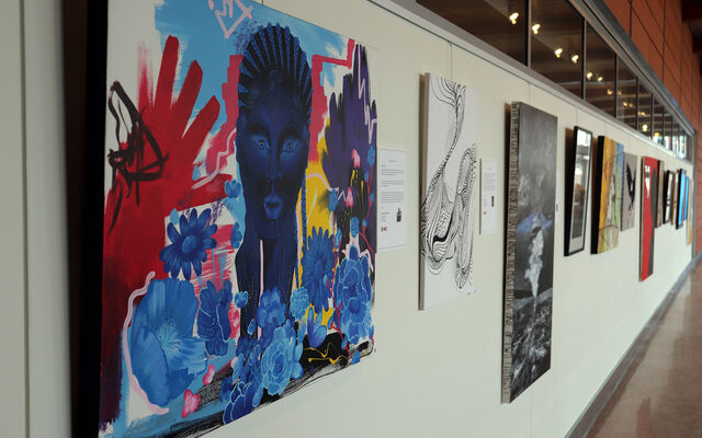 Many "Voices Unbounded" paintings hang along the second-floor catwalk at City Hall.