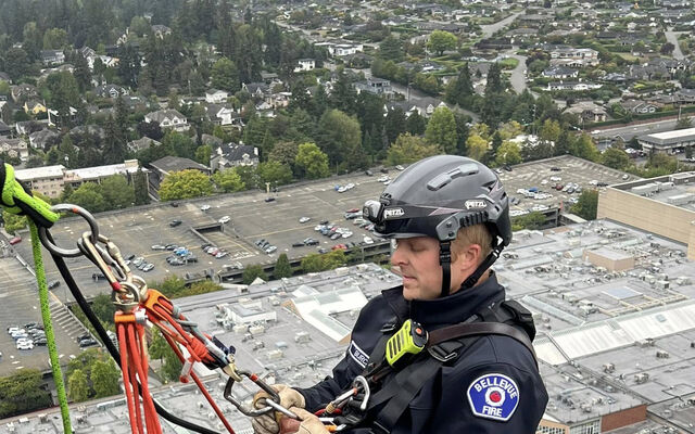 A Bellevue firefighter hangs from the side of a Bellevue high-rise during training for urban rescues.