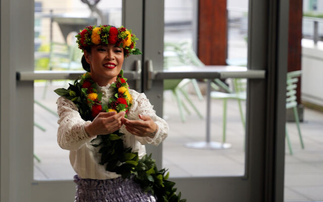 A woman with flowers in her hair dances at City Hall.