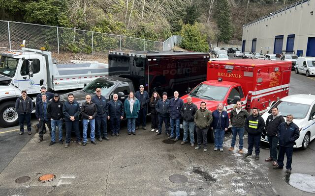 The Fleet team stands in front of some trucks.