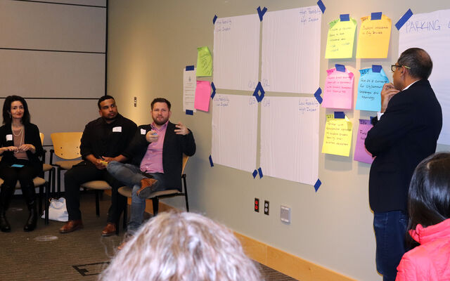 A man shares his idea at an Inclusive Innovation Forum in March 2025 as other participants and the moderator look on.