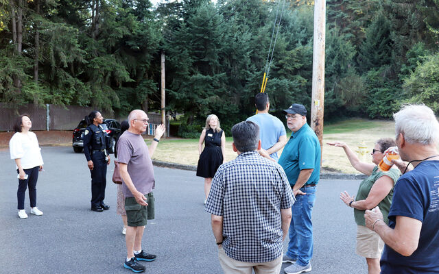 People talk on a street in Surrey Downs for Neighborhood Walks.