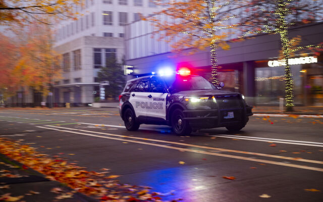A Bellevue police SUV with lights flashing proceeds along 108th Avenue Northeast in downtown Bellevue.