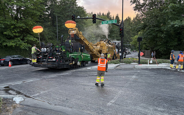A paving machine runs past 112th Avenue Southeast.