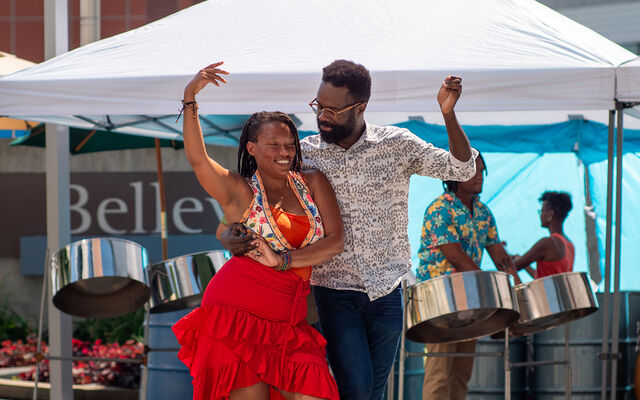 A couple dances, with a band behind them under a canopy, at Swing Arts Foundation's free jazz and swing dance lesson social at City Hall Plaza. 
