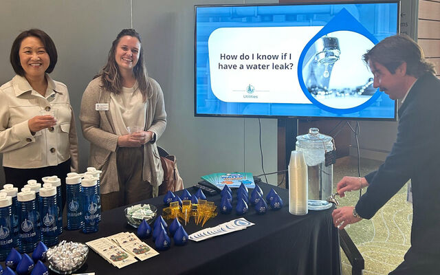 Utilities staff stand behind the Water-Smart Table in 2025.