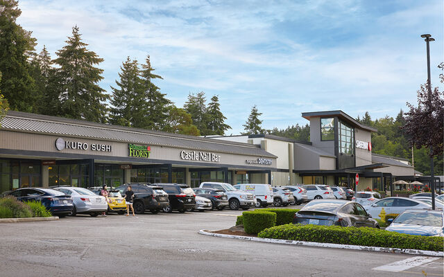 A row of restaurants and shops and the parking lot in front of them