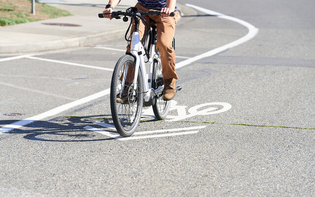 A person rides an e-bike on a Bellevue street.