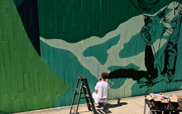 A man paints a mural.