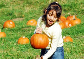 A girl picks a pumpkin at the Kelsey Creek Farm Fair.