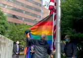 Staff raise a rainbow flag at City Hall for Pride Month.