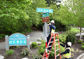 Transportation workers install an honorary street sign celebrating sister city Yao, Japan.