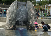 A little girl checks out the waterfall at the Inspiration Playground at Downtown Park.