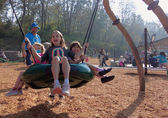 Kids play on the swing at Newport Hills Woodlawn Park.