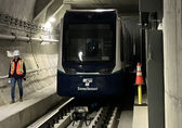 A Sound Transit worker walks in the Bellevue downtown tunnel as a rail car goes by.