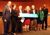 Councilmember Jennifer Robertson accepts a commendation and personalized street sign from the City Council.