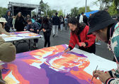 People paint on a large sheet at a BelRed arts event.