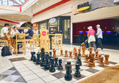 People shop or visit at the Crossroads Bellevue mall by a large chess set. Photo by Stanton Stephens
