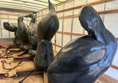 Large sculptures of extinct birds are in a wood-framed, canvas storage box.
