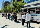 People line up for lunch at Momo's Kebabs food truck, which is parked at City Hall..