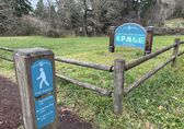 A trail to the Coal Creek Natural Area with a signpost.