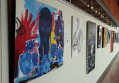 Many "Voices Unbounded" paintings hang along the second-floor catwalk at City Hall.