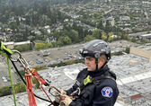 A Bellevue firefighter hangs from the side of a Bellevue high-rise during training for urban rescues.