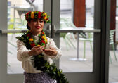 A woman with flowers in her hair dances at City Hall.