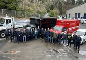 The Fleet team stands in front of some trucks.