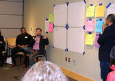 A man shares his idea at an Inclusive Innovation Forum in March 2025 as other participants and the moderator look on.