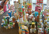 A variety of canned and boxed food is stacked up in a pile.